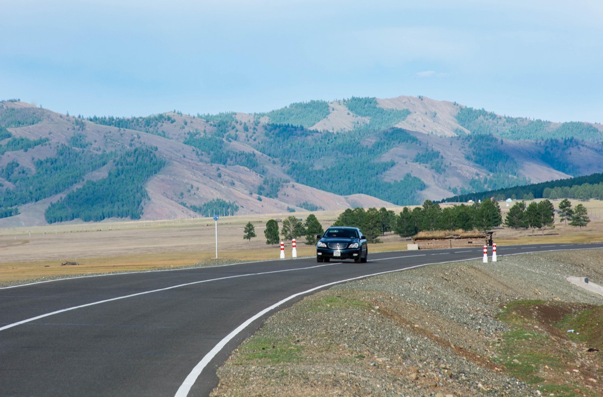Dirt road crossing the open Mongolian steppe — getting around Mongolia